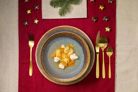 Christmas dinner table setting with soup bowl and festive decorations Stock Photos