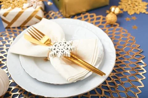 Christmas festive table setting with white plates and gold cutlery, gifts i.. Stock Photos