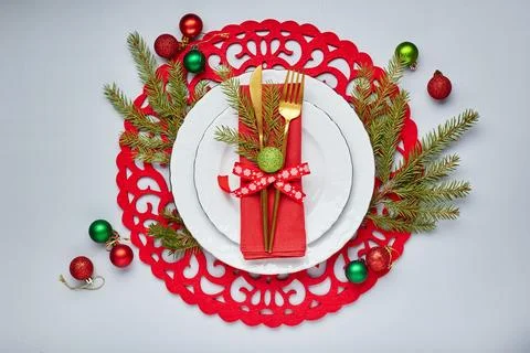 Christmas festive table setting with white plates and gold cutlery, red lin.. Stock Photos