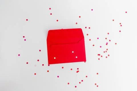 Christmas flat lay with open empty red envelope with confetti around, abstract Stock Photos