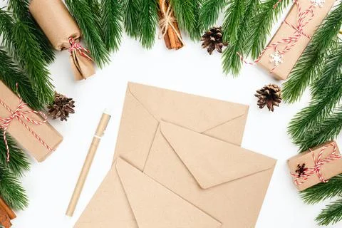 Christmas flat lay from stack of craft envelopes framed with spruce twigs, cones 写真素材