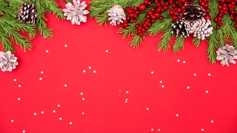 Christmas flat lay stop motion. tree branches with cones on a red background Stock Footage