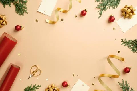 Christmas frame flat lay with red wrapping paper, gold ribbons, scissors, a.. Stock Photos