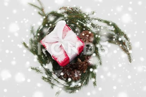 Christmas gift and fir wreath with cones on snow Stock-Fotos