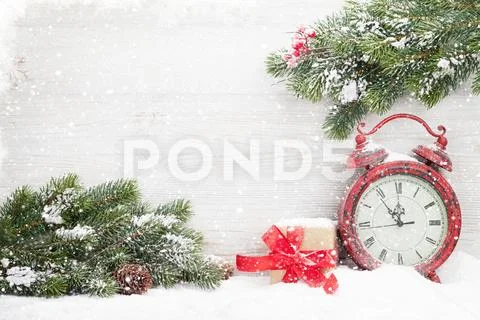 Christmas gift box, alarm clock and fir tree branch Stock Photos