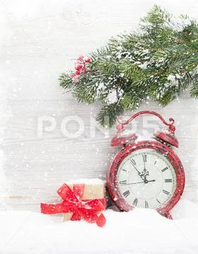 Christmas gift box, alarm clock and fir tree branch Stock Photos