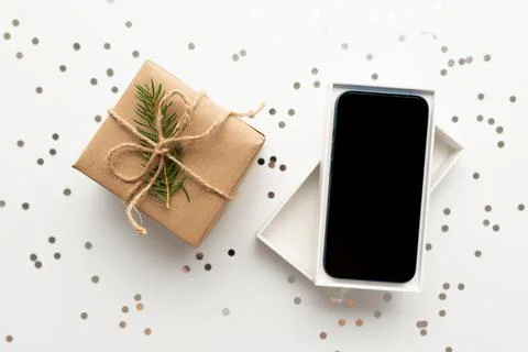 Christmas Gift box with mobile phone and New Year decoration Stock Photos
