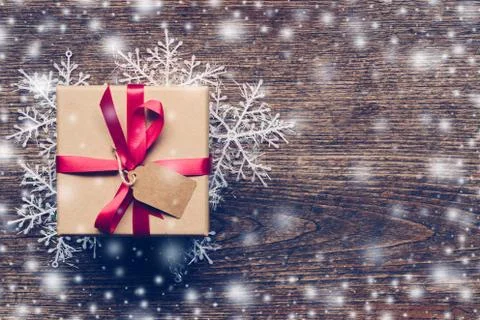 Christmas gift box placed and white snowflakes on wooden planks with white sn Stock Photos