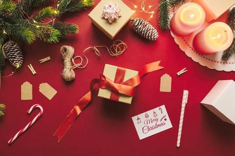 Christmas gift box preparation with rustic decor stuff on a red background. M Stock Photos
