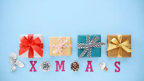Christmas gift boxes and pine cone with xmas word on blue background with cop Stock Photos