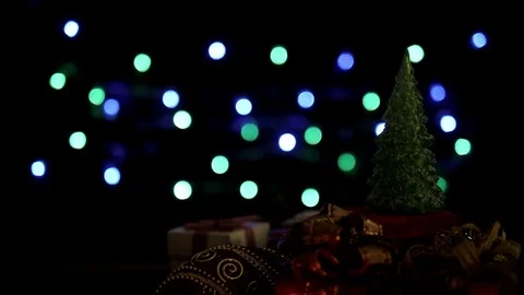 Christmas gift boxes, ball and Christmas tree on colorful bokeh lights Stock Footage 81363531