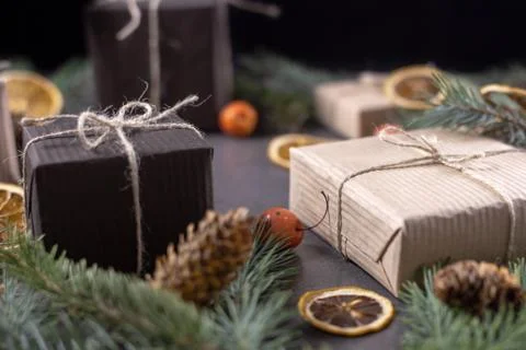Christmas gift boxes with pine branches and dried oranges on dark texture sur Stock Photos