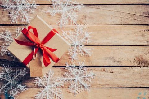 Christmas gift boxes placed and white snowflakes on wooden planks with space. Stock Photos
