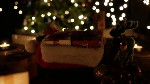Christmas gift boxes in santa hat with reindeer and candle on bokeh light Stock Footage 81435425