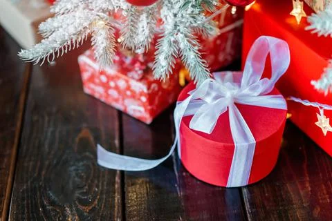 Christmas gift boxes under the tree, on the wooden floor. Stock Photos