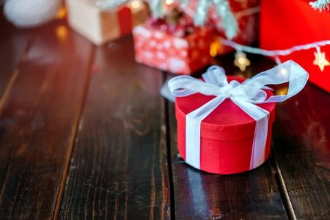 Christmas gift boxes under the tree, on the wooden floor. Stock Photos