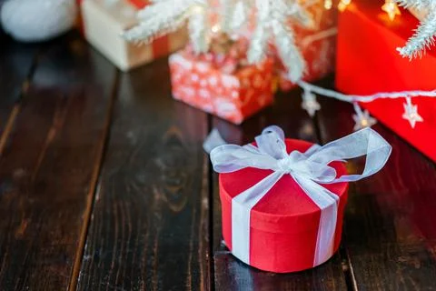 Christmas gift boxes under the tree, on the wooden floor. Stock Photos