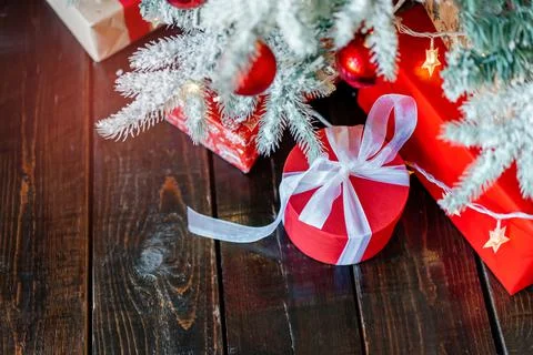 Christmas gift boxes under the tree, on the wooden floor. Stock Photos