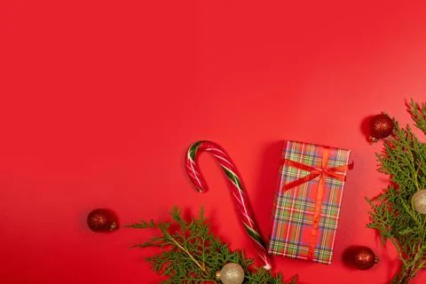 Christmas gift candy cane branches and ornaments on red background Stock Photos