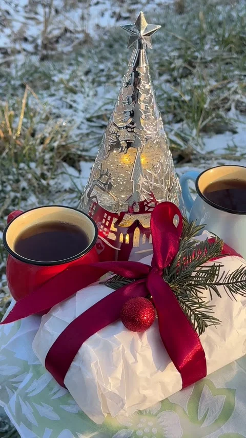 Christmas gift, decorative xmas tree, hot tea mugs, winter snow background Stock Footage 344013365