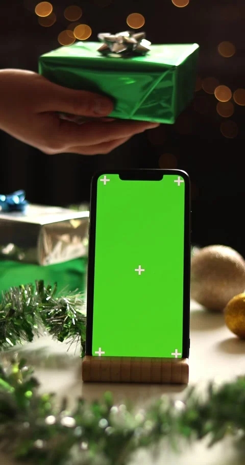 Christmas gift exchange with green screen phone and festive bokeh lights Stock Footage 339073064