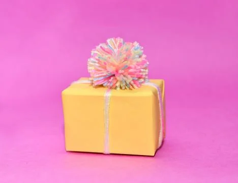 Christmas gift isolated on a bright pink background. yellow holiday box wool Stock Photos