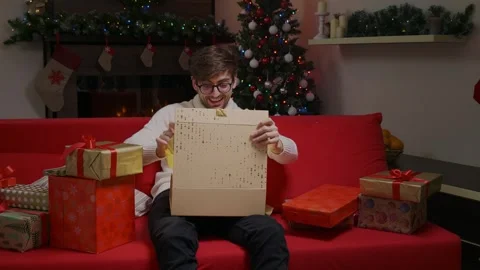 Christmas gift man opening present with surprised face laughing. Stock Footage 314780836