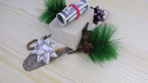 Christmas gift of a roll of 100 dollar banknotes presented in a small wooden box Vídeo Stock 145535451