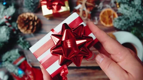 Christmas gift, top-down view. Male hands a box with a gift over a festive table Stock Footage 144955061