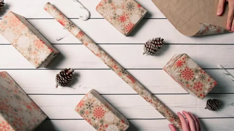 Christmas Gift Wrapping Hands Preparing Presents on a Rustic Wooden Table 库存影片 331106987