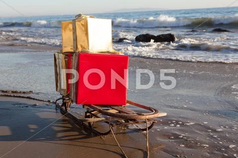 Christmas gifts on a sled on the beach in Malibu Stock Photos