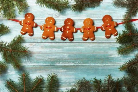 Christmas gingerbread cookies on an old board surrounded by fir branches Stock Photos