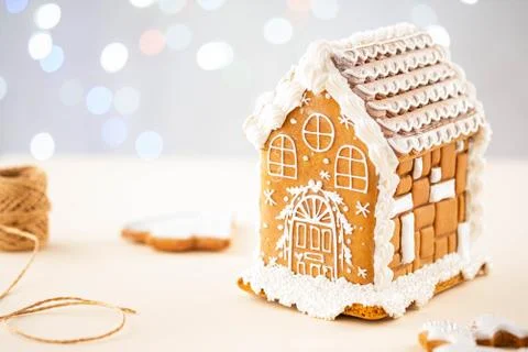 Christmas gingerbread house decoration on background of defocused lights. Hand Stock Photos