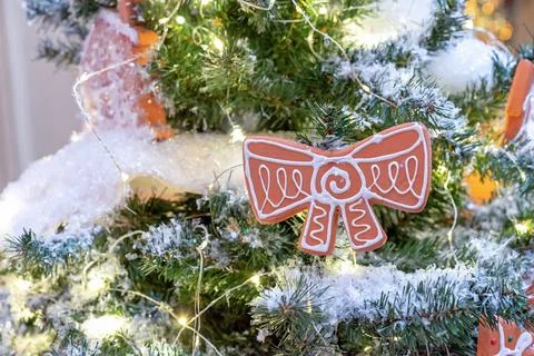 Christmas gingerbread with icing in the shape of a bow on the Christmas tree. Stock Photos