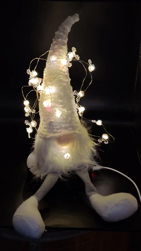 Christmas gnome with burning lights on a dark background moving Stock Footage 323760840