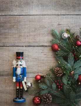 Christmas greenery, decorations and nutcracker against wood backdrop. Foto stock