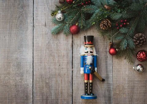 Christmas greenery, nutcracker and decorations against wood backdrop. Foto stock
