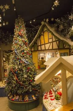 Christmas interior in the store: with a large tree with toys, gingerbread houses Stock Photos