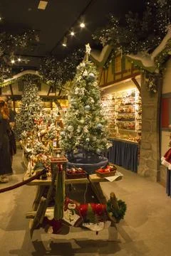 Christmas interior in the store: with a large tree in toys, gingerbread houses. Stock Photos