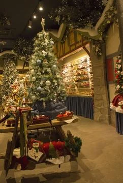 Christmas interior in the store: with a large tree in toys, gingerbread houses. Stock Photos