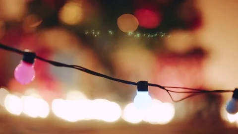Christmas lanterns burning and illuminated decorated christmas tree out of focus Stock Footage 73896632