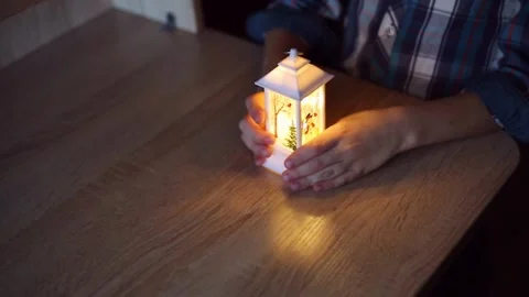 Christmas lanterns in the hands of a child, which he lights and examines Stock Footage 220218527