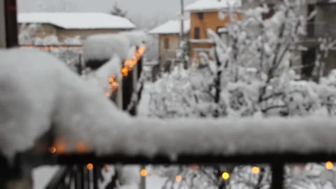 Christmas lights on the balcony of a cabin while it is snowing Stock Footage 144836688