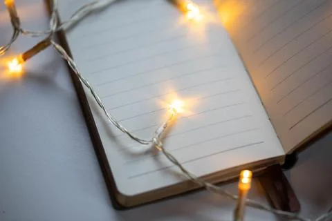 Christmas lights on an empty notebook page Stock Photos