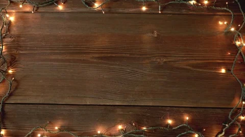 Christmas lights frame loop on rustic wooden background. Stock Footage 284575992