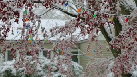 Christmas lights in front of house during snow storm slow motion Stock Footage 83399754