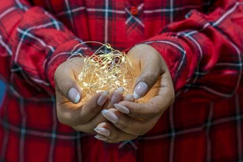 Christmas lights on hands Stock Photos