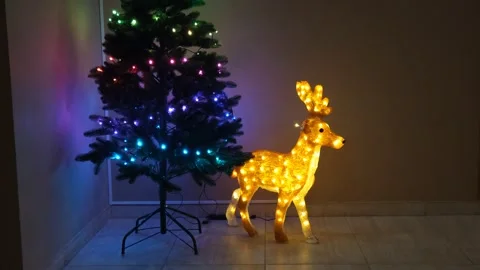 Christmas lights on the tree and a deer figurine Stock Footage 322191086