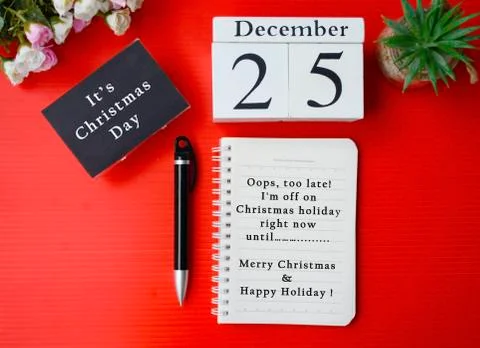 Christmas message written on notepad with white cube and red background Stock Photos