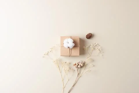 Christmas minimal composition with packaging gift in craft paper and flowers  Stock Photos
